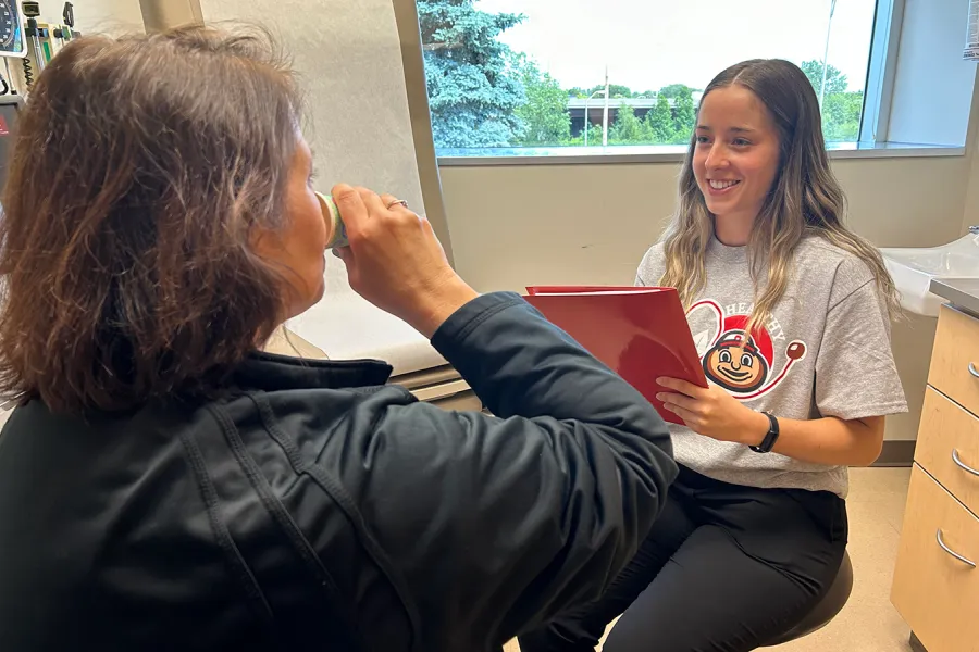 Student conducting screening to patient