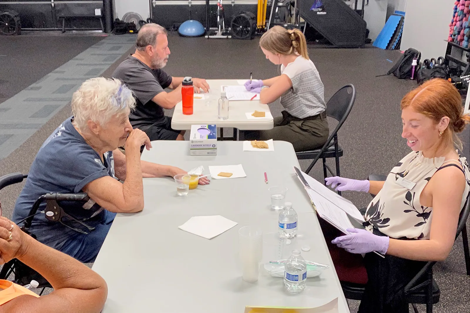 Clients seated at table while students perform evaluations